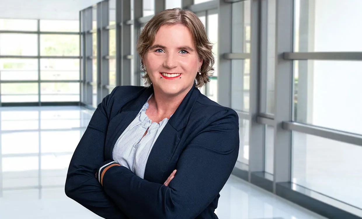 Business-Porträt einer Frau in Schleswig vor einer unscharfen Glasfassade, Teil einer Personal-Branding-Serie, mit natürlichem Licht und professioneller Ausstrahlung; der Hintergrund wurde nachträglich ersetzt.